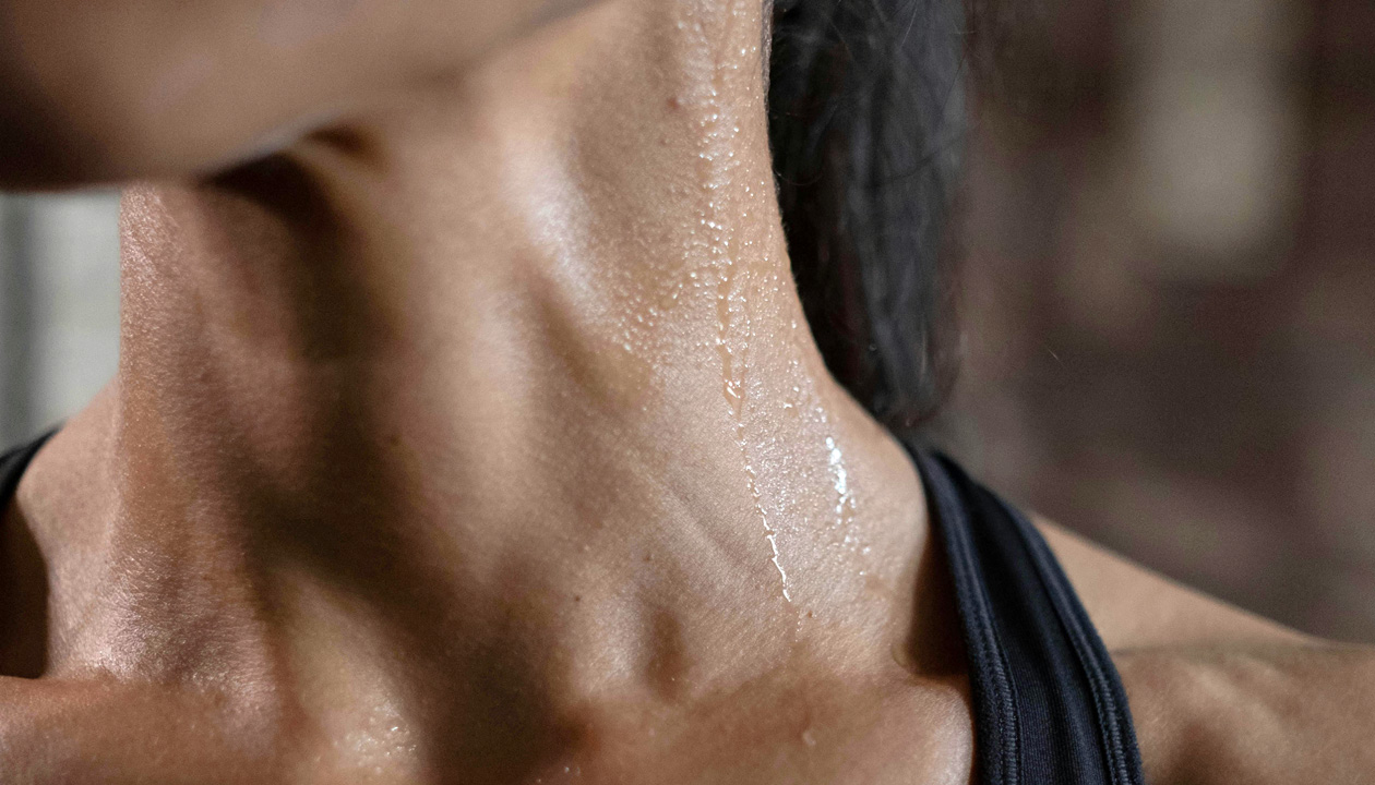 A woman with visible sweat on her neck, indicating exertion or heat.